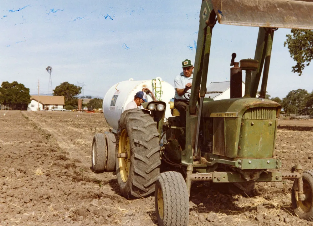 George Steinbeck on tractor with Howie hose watering babies by hand,1982.